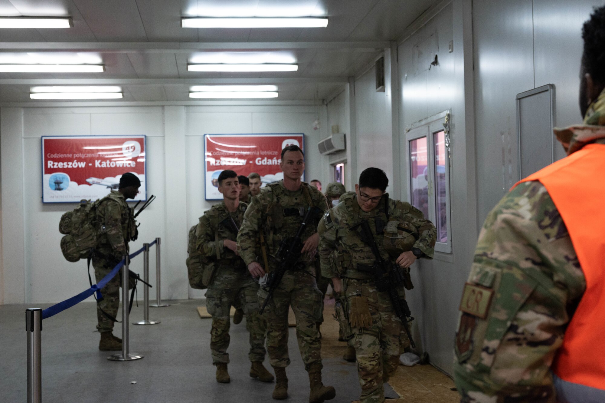 Army soldiers walk towards an in-processing line.
