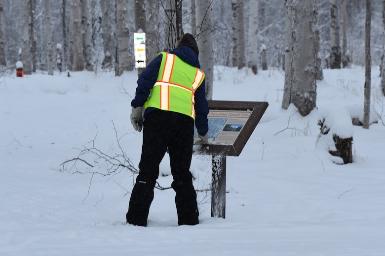 Julie Anderson, chief of the Operations Branch at the U.S. Army Corps of Engineers – Alaska District, clears snow from an interpretive display for the Chena River Nature Trail on Dec. 7 at the Chena River Lakes Flood Control Project in North Pole, Alaska.
