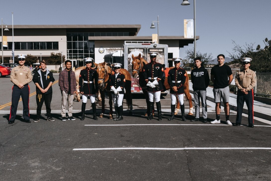 Future Marines with Recruiting Sub-Station Mission Viejo, Recruiting Station Orange County, pose with the Marine Corps Mounted Color Guard after having the opportunity to conduct a meet and greet with the Marines in Laguna Niguel, California on Dec. 11, 2021. The Marine Corps Mounted Color Guard has been a part of the Marine Corps since 1950. They have performed in various parades, ceremonies and rodeos across the nation. (U.S. Marine Corps photo by Sgt. Sarah Ralph)