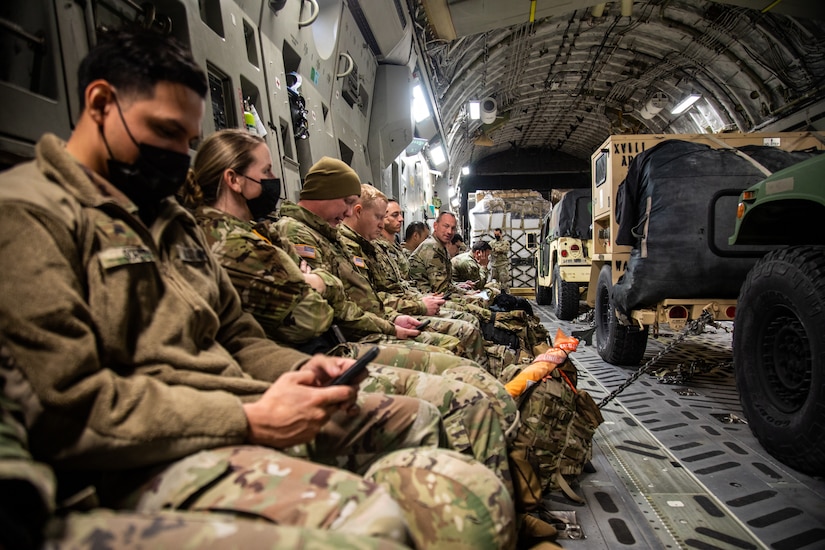 Paratroopers sit aboard a C-17 transport aircraft.