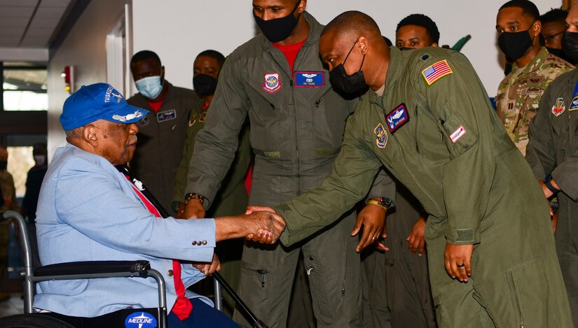 Dr. Eugene J. Richardson Jr., Documented Original Tuskegee Airman, and U.S. Air Force Lt. Col. Robert L. Moore Jr., 15th Airlift Squadron commander, shake hands during The Accelerating the Legacy showcase at Joint Base Charleston, South Carolina, Feb. 18, 2022. The Accelerating the Legacy showcase honors the legacy of the heroic Tuskegee Airmen in a two-day event highlighting professional development and community outreach.