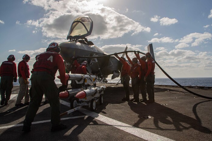 PHILIPPINE SEA - The ordnance department of Marine Wing Fighter Attack Squadron 314, works diligently to refuel and load their F-35C Lightning II with the AIM-120 advanced medium-range air-to-air missile as VMFA-314 performs simulated offensive and defensive air operations, as well as close air support training missions in support of Jungle Warfare Exercise 22 across Okinawa, Japan. JWX 22 is large-scale field training exercise focused on leveraging the integrated capabilities of joint and allied partners to strengthen all-domain awareness, maneuver, and fires across a distributed maritime environment. (U.S. Marine Corps photo by Capt. Charles Allen/Released)