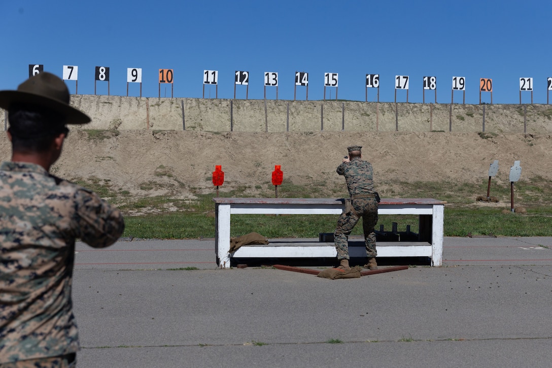 A Marine shoots his weapon at targets.