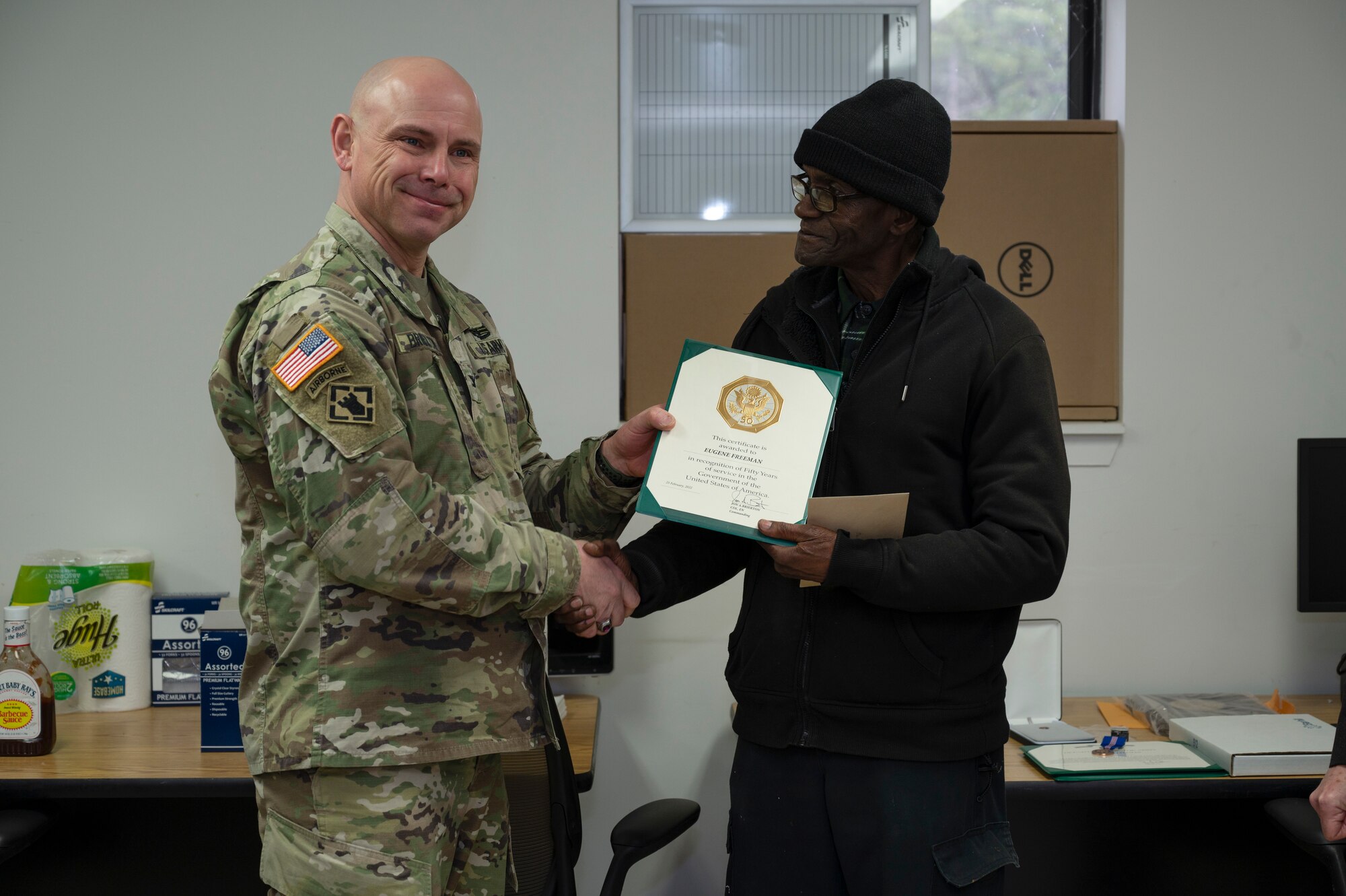 U.S. Army Col. Jon Brierton, Joint Base McGuire-Dix-Lakehurst, N.J., deputy commander, presents Eugene Freeman, Army Support Activity-Fort Dix Training Division carpenter, with an award during a retirement ceremony, Feb. 24, 2022. Freeman is the division’s longest term employee having served more than 50 years. He originally joined the military after being drafted into the Vietnam War, after returning to New Jersey he continued serving the U.S. as a civilian. (U.S. Air Force photo by Senior Airman Ariel Owings)