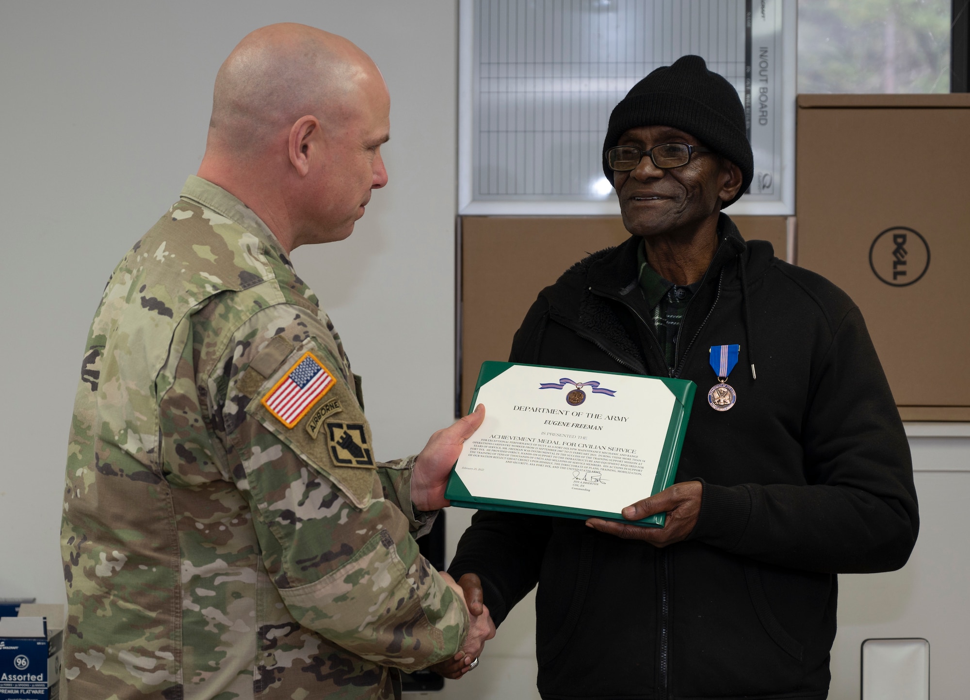 U.S. Army Col. Jon Brierton, Joint Base McGuire-Dix-Lakehurst, N.J., deputy commander, presents Eugene Freeman, Army Support Activity-Fort Dix Training Division carpenter, with an achievement award during a retirement ceremony, Feb. 24, 2022. Freeman is the division’s longest term employee having served more than 50 years. He originally joined the military after being drafted into the Vietnam War, after returning to New Jersey he continued serving the U.S. as a civilian. (U.S. Air Force photo by Senior Airman Ariel Owings)