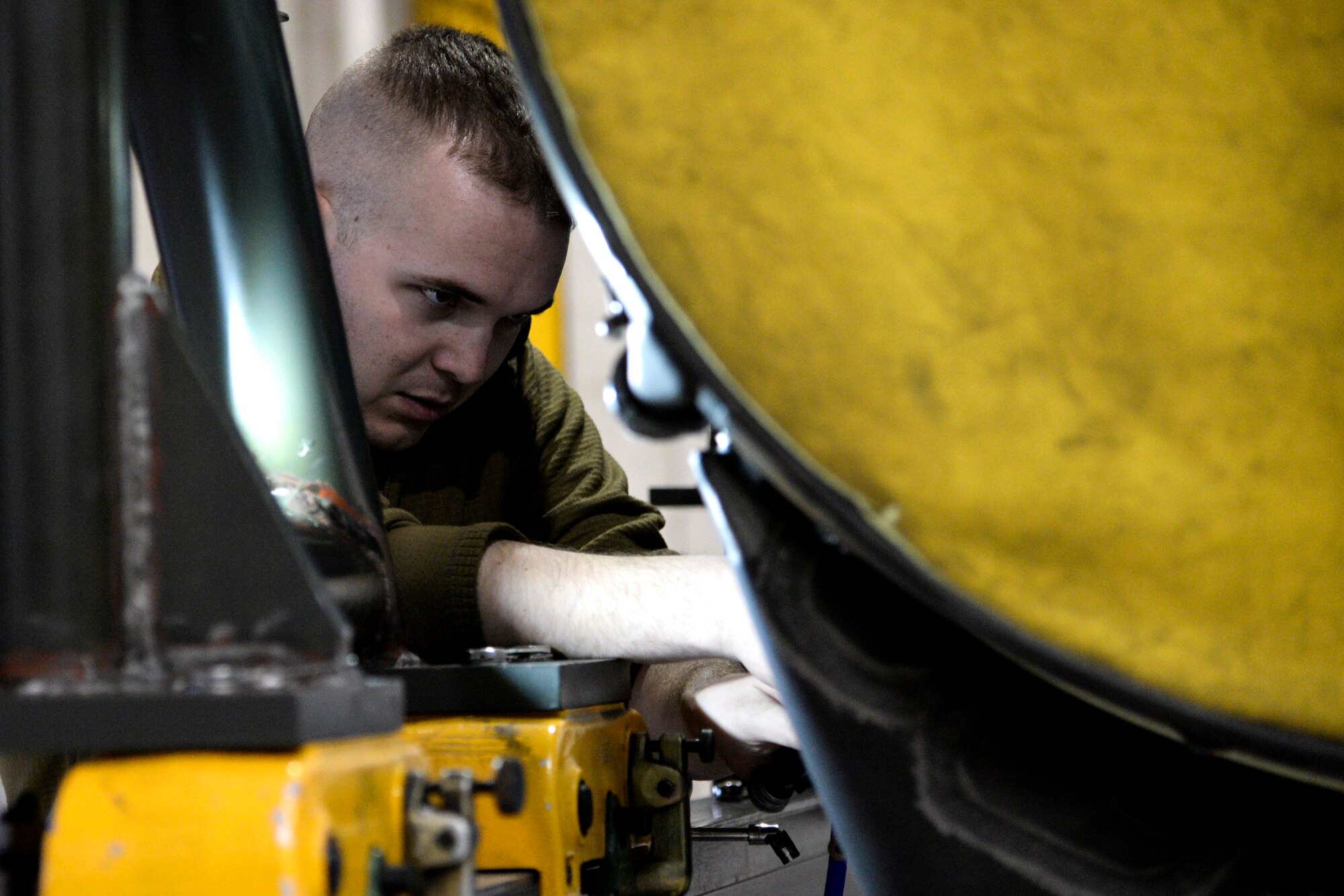 An image of U.S. Air Force Staff Sgt. John Dilks, 177th Maintenance Group engine mechanic, repairing a turbofan engine.