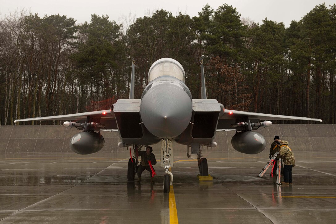 An F-15 aircraft is being serviced on a flightline.