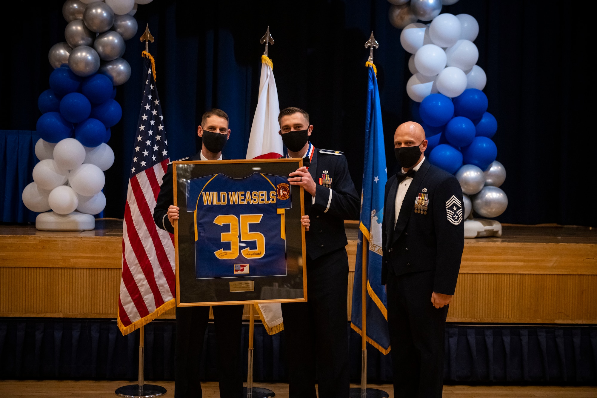 A military member poses with leadership after winning the annual award.
