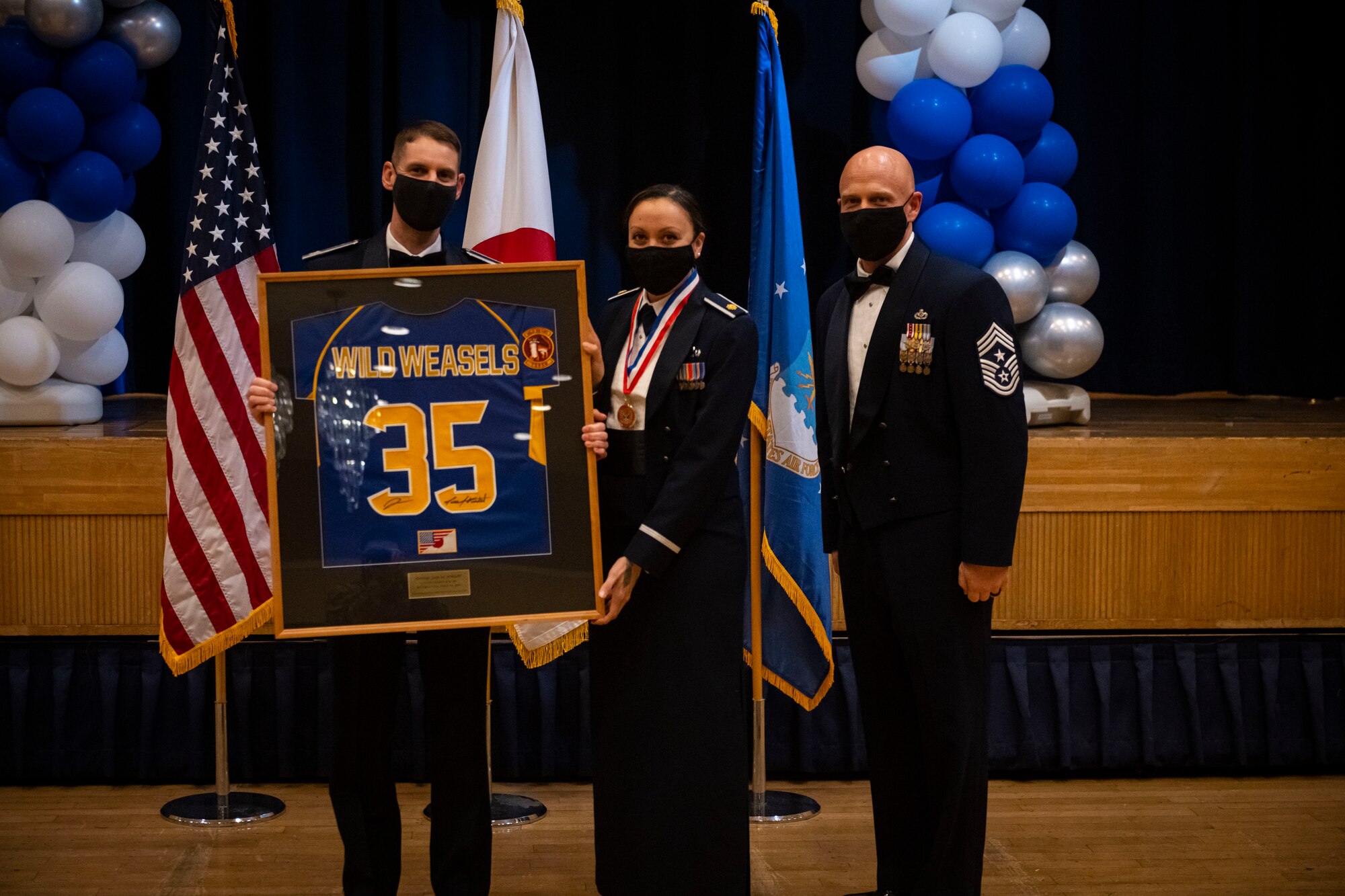 A military member poses with leadership after winning the annual award.