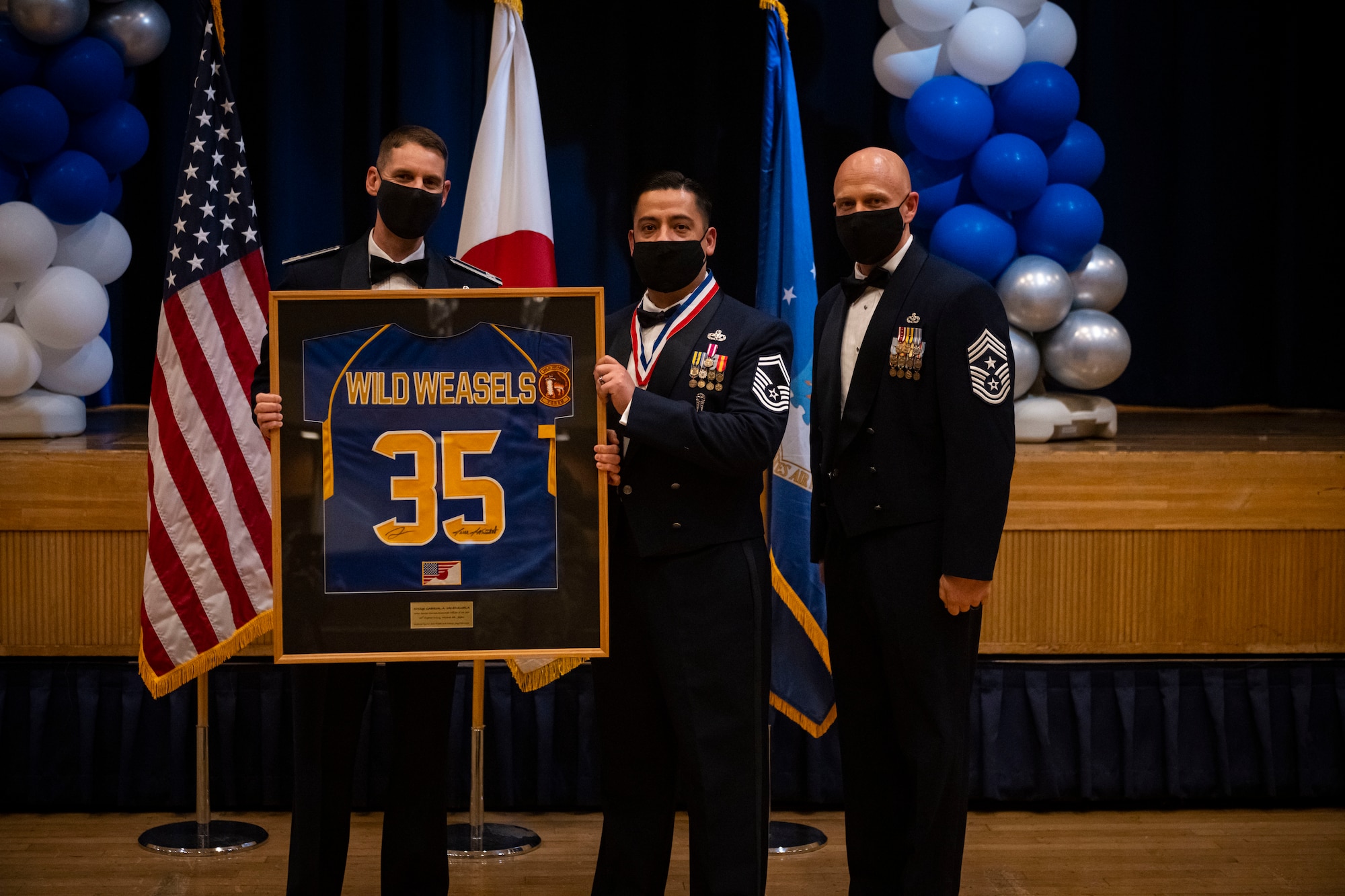 A military member poses with leadership after winning the annual award.