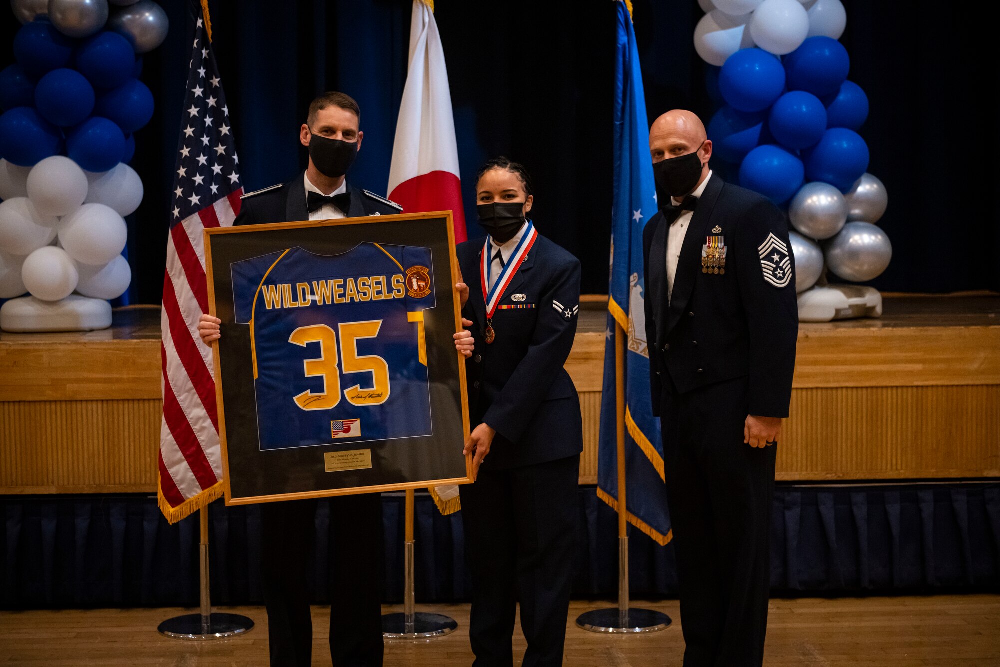 A military member poses with leadership after winning the annual award.