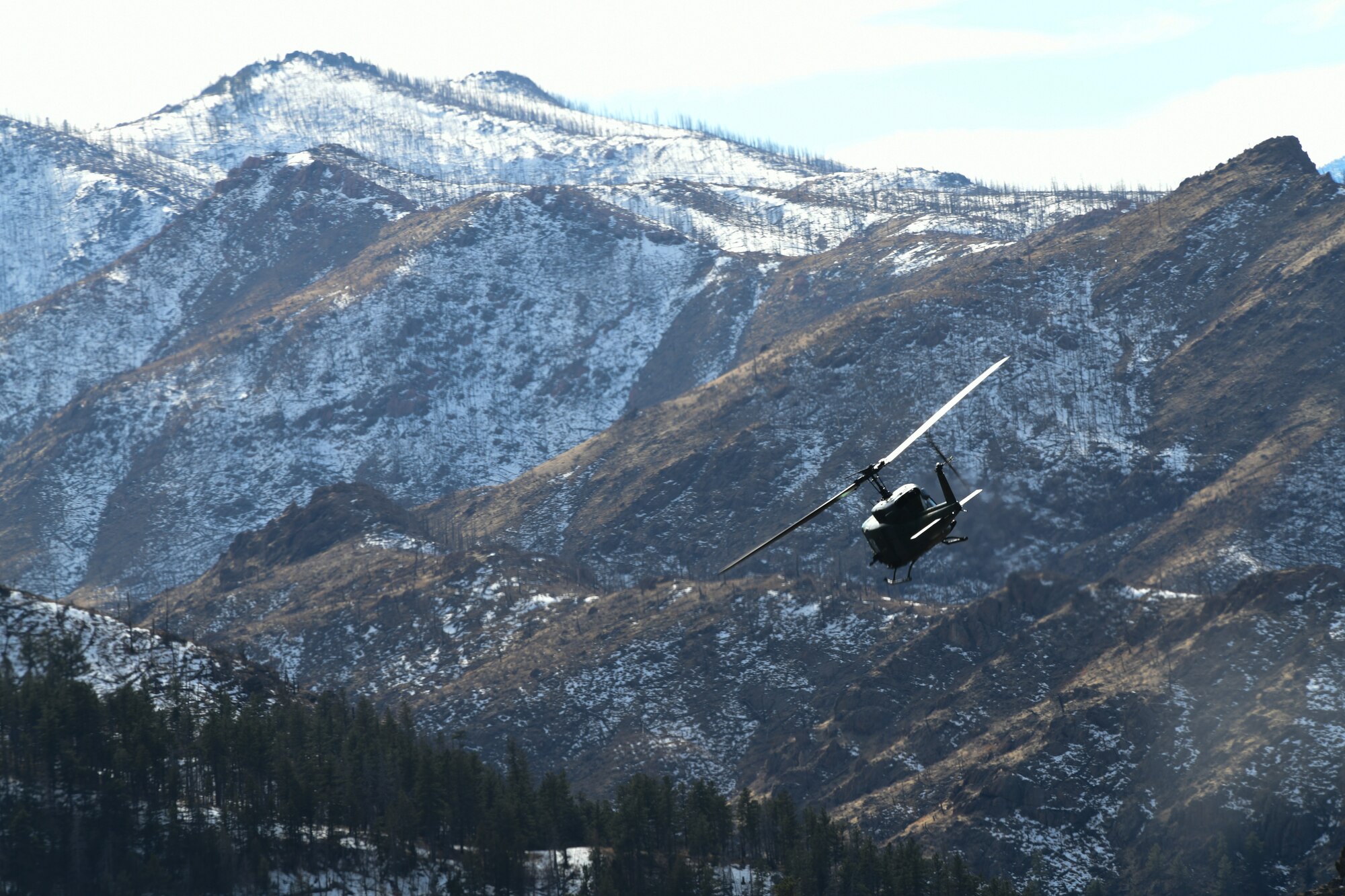 A 37th Helicopter Squadron helicopter flies through Poudre Canyon, Colorado, February 15, 2022. The 37 HS flies through many different types of terrain for training purposes in order to stay mission ready and lethal at all times. (U.S. Air Force photo by Airman Sarah Post)