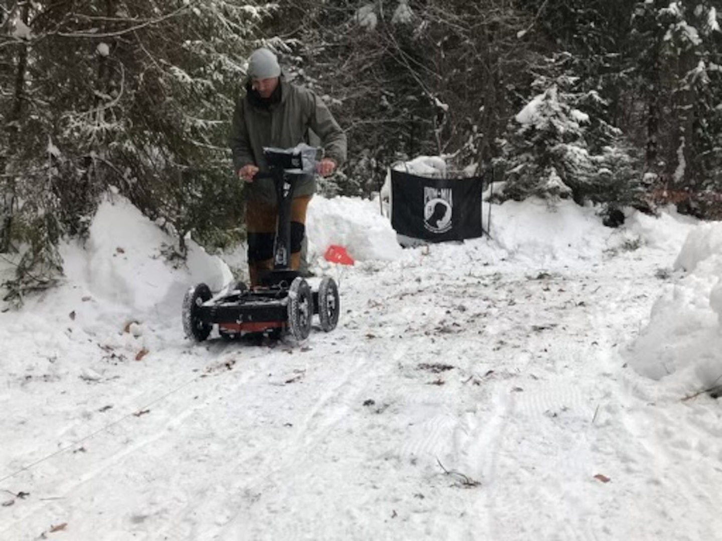 A Defense POW/MIA Accounting Agency investigative team member uses ground penetrating radar in Poland, January 2022. The DPAA teams put up a POW/MIA flag at all sites as a reminder for what they are working. (Courtesy photo)