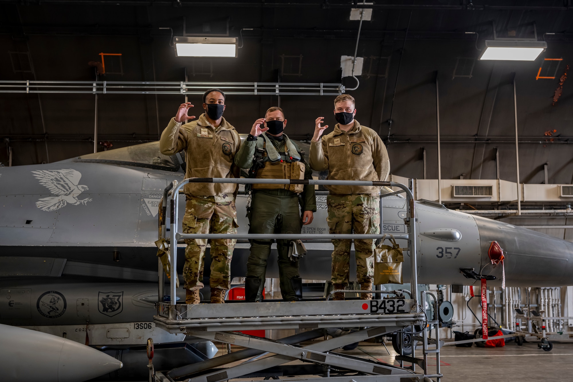 Airmen posing in front of an F-16 Fighting Falcon.