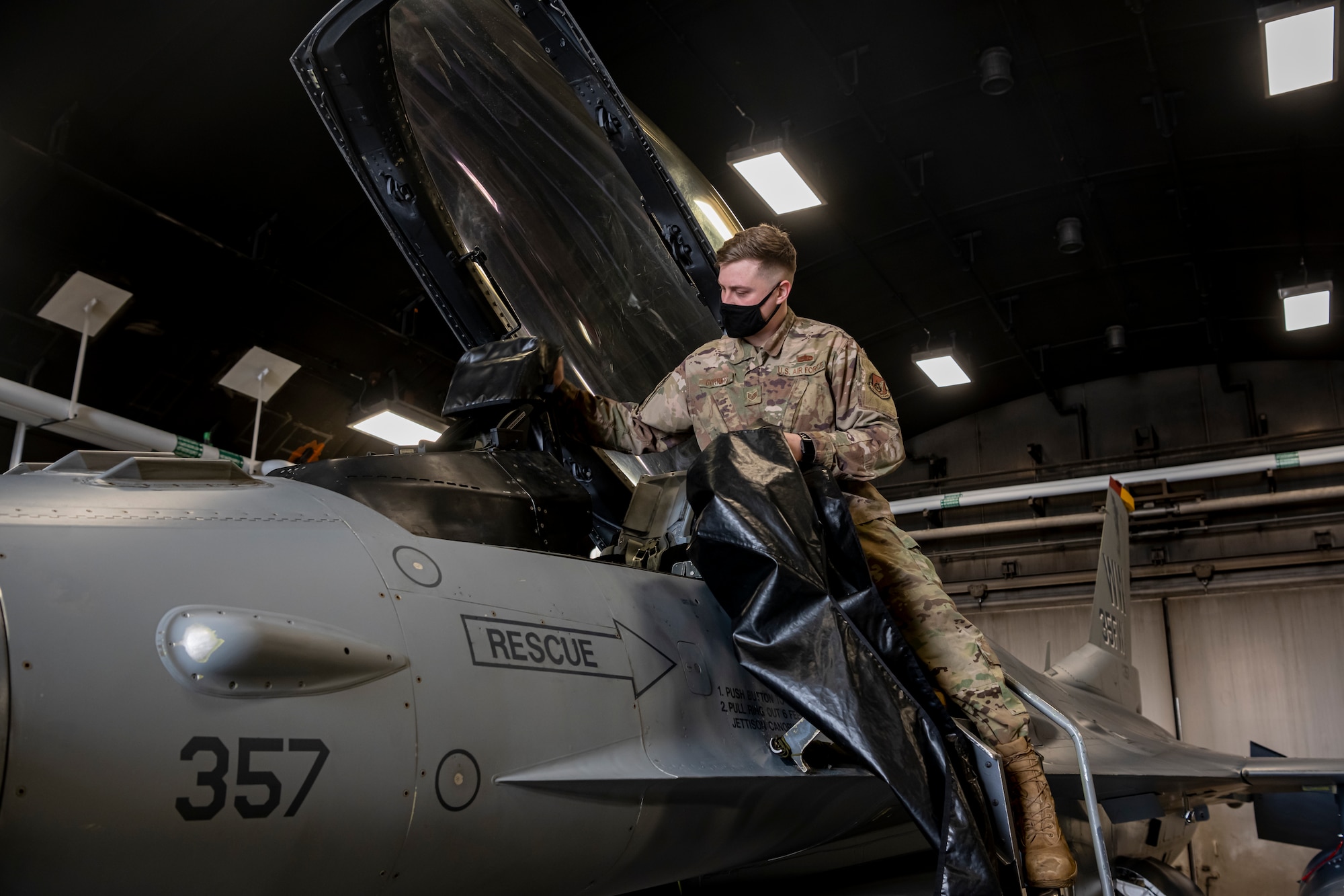 Airman removing covers from an F-16 Fighting Falcon.