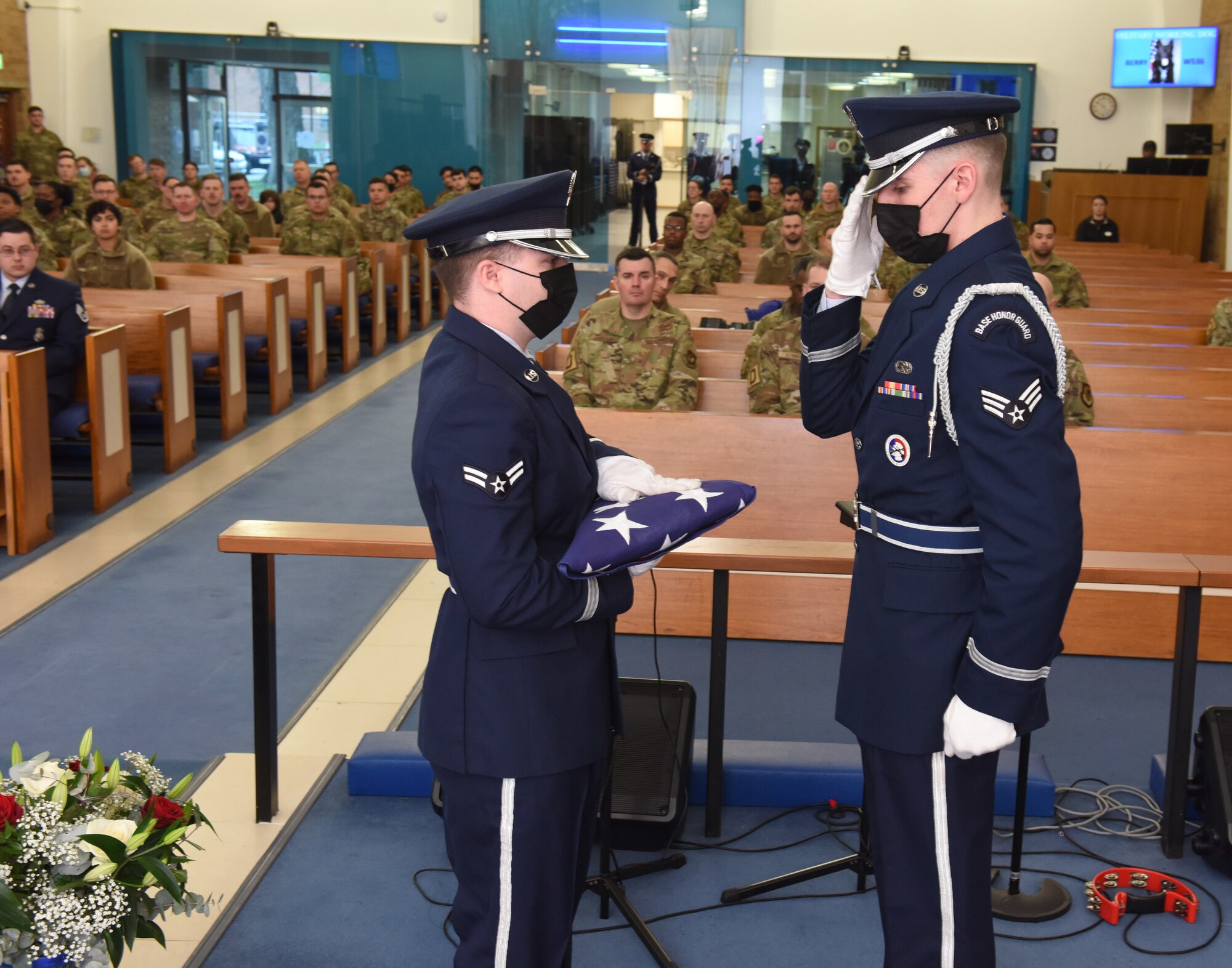 Members of the Team Mildenhall Honor Guard hand off the Stars and Stripes flag to one another during a memorial service to honor Military Working Dog Berry at Royal Air Force Mildenhall, England, Feb. 24, 2022. Members of the 100th Security Forces Squadron MWD section held a ceremony to remember the fallen K-9 hero so others could come together and pay their respects. (U.S. Air Force photo by Karen Abeyasekere)
