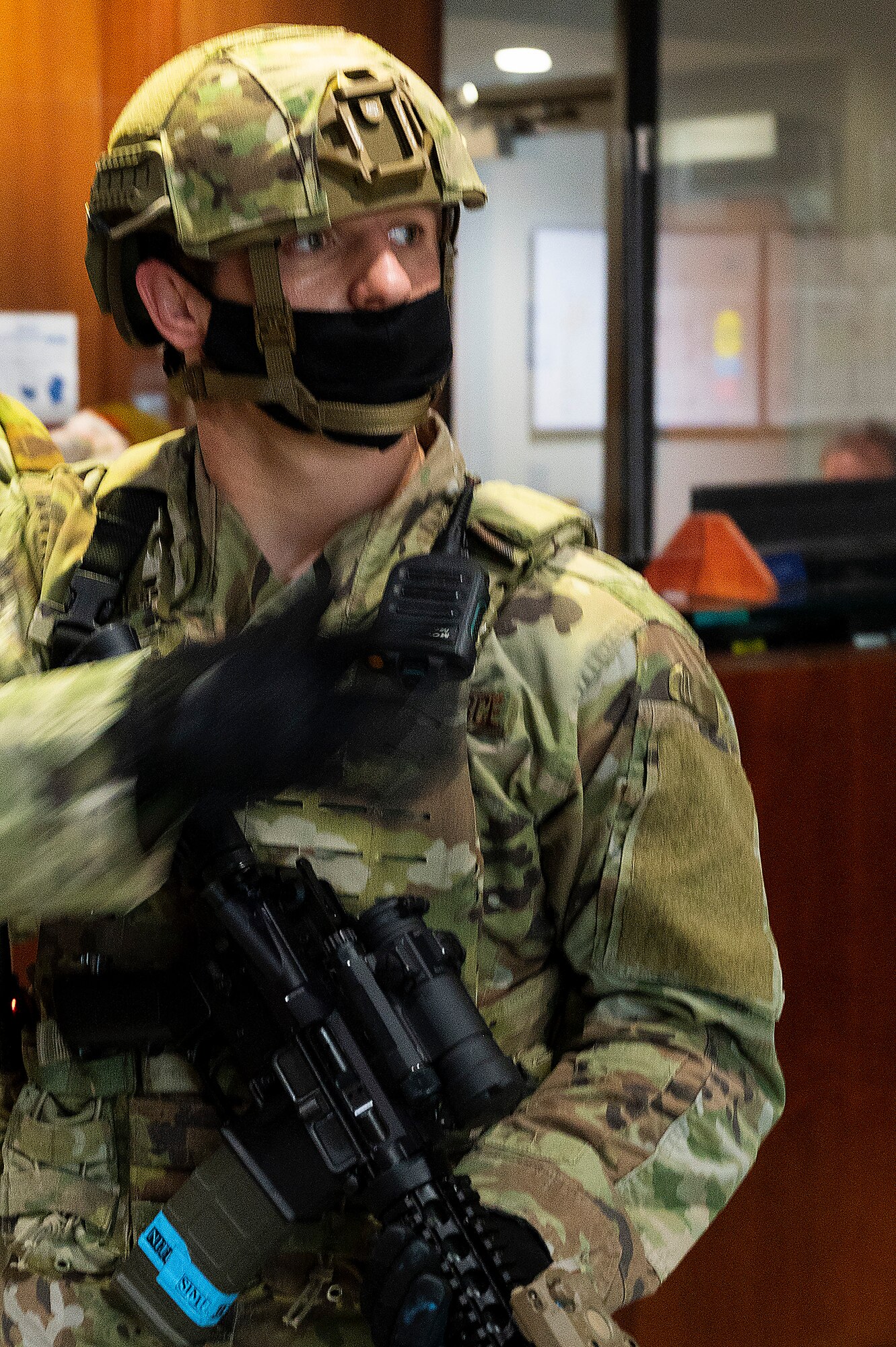 A Defender with the 88th Security Forces Squadron reaches for his radio during an active-shooter exercise Feb. 23, 2022, at Wright-Patterson Air Force Base, Ohio. The exercise gave first responders, including police, fire and medical personnel, the opportunity to practice coordinating emergency actions and procedures. (U.S. Air Force photo by R.J. Oriez)