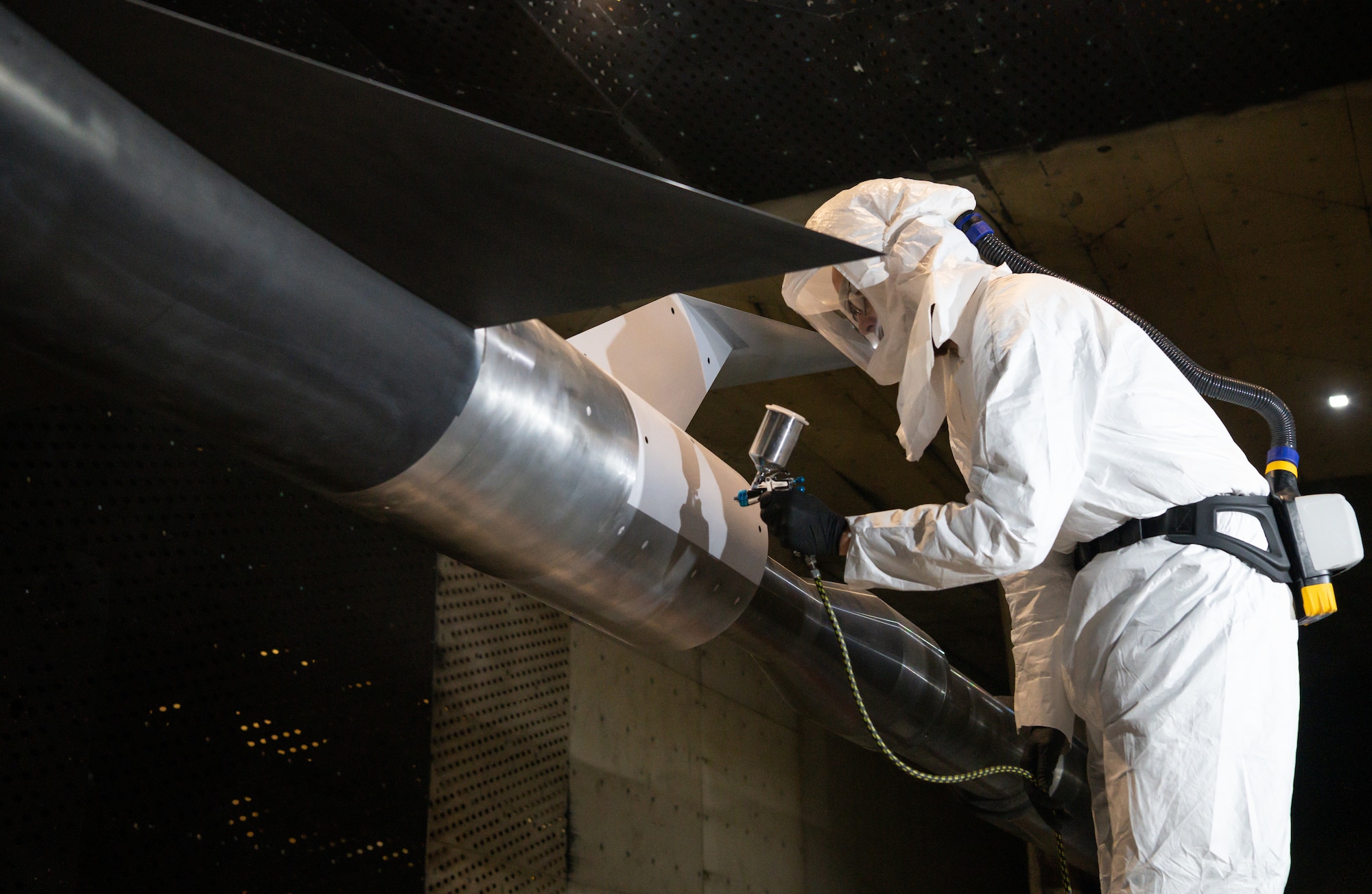 Ben Howell sprays pressure sensitive paint onto an AGARD-C model installed in the 16-foot transonic wind tunnel at Arnold Air Force Base, Tenn.