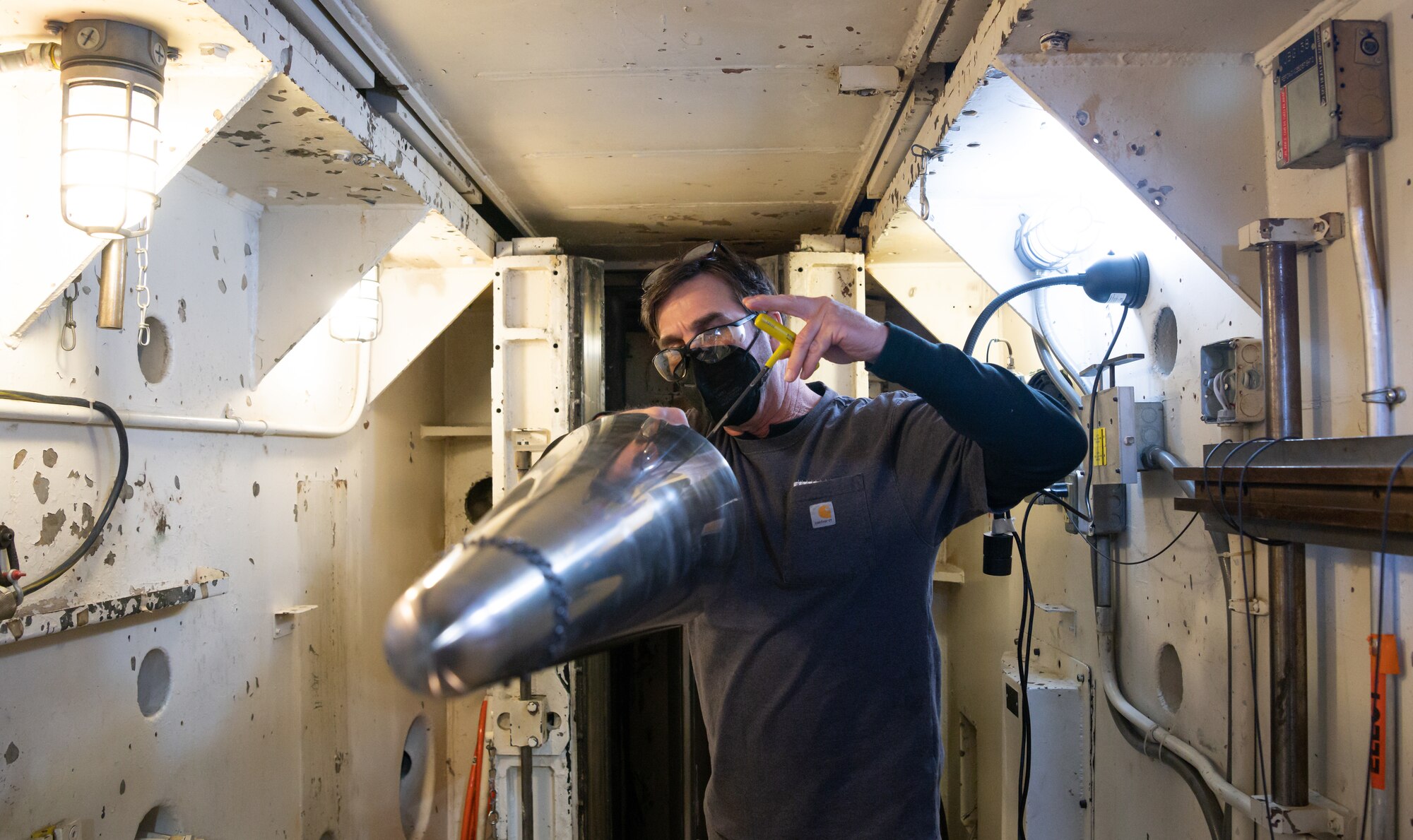 Adam Gilliland works on a standard test model in the area below the test cell of Tunnel C in the von Kármán Gas Dynamics Facility at Arnold Air Force Base, Tenn.