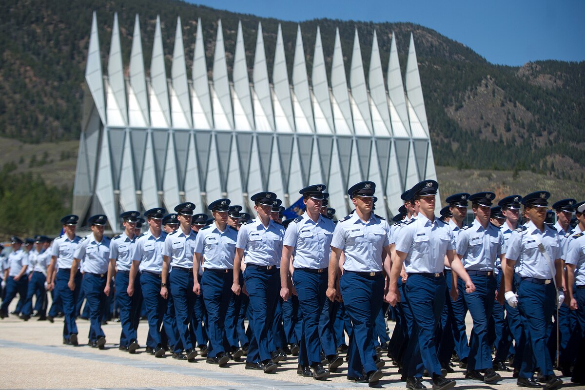 Many uniformed individuals march in a formation.