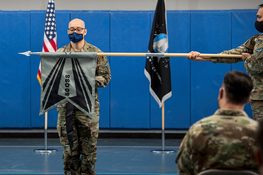 U.S. Space Force Lt. Col. John Paek, 8th Combat Training Squadron commander, furls the squadron guidon during the 50th Operations Support Squadron deactivation ceremony at Schriever Space Force Base, Colorado, Feb. 8, 2022.