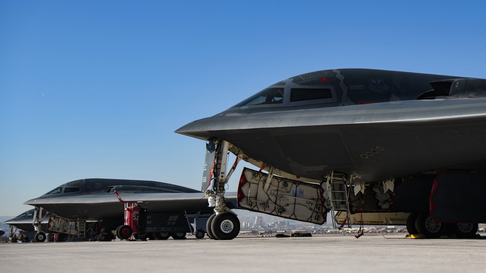 Three B-2 Spirits sit on the Nellis Air Force Base flightline.