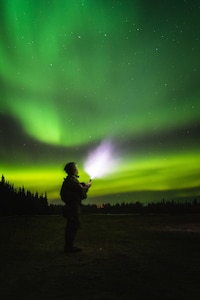 Soldier stands under northern lights in Alaska.