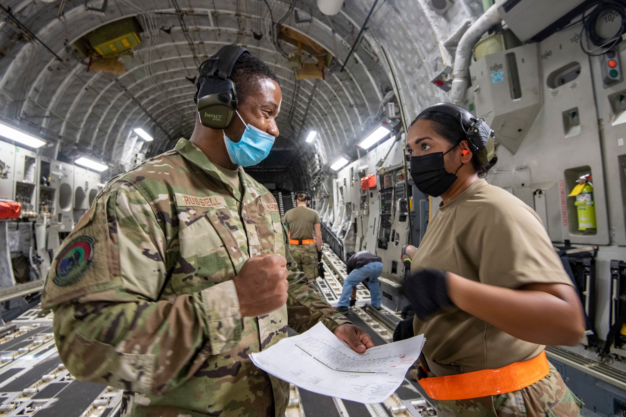 Staff Sgt. Rontrell Russell (left) and Senior Airman Nigeleene Eltagonde, 48th Aerial Port Squadron, cargo specialists, discuss the manifest to ensure all cargo has been accounted for while on a Hawaii Air National Guard C-17 from the 154th Wing, Joint Base Pearl Harbor-Hickam, Jan. 20, 2022.