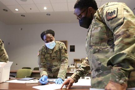 Army Capt. Whennah Andrews, executive officer of the Army National Guard Office of the Chief Surgeon, explains a patient documentation form to a service member during training on procedures to test National Guard members for COVID-19 at the Herbert R. Temple Army National Guard Readiness Center, Arlington, Virginia, Jan. 22, 2022. The training provided guidance for National Guard Bureau service members assigned to test for the virus as part of COVID-19 response operations.