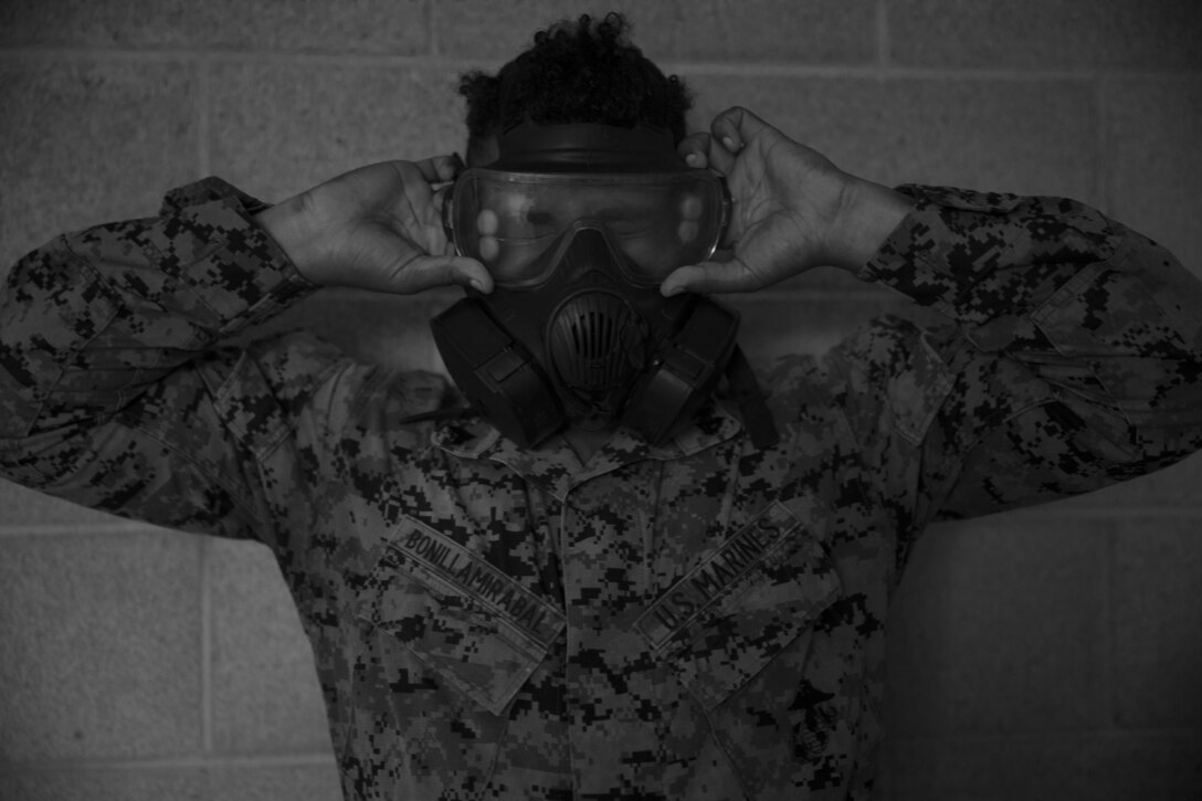 U.S. Marine Corps Cpl. Carlos Bonilla, a satellite communications operator with 9th Communications Battalion, I Marine Expeditionary Force Information Group, breaks the seal of his gas mask during chemical, biological, radiological and nuclear defense training at Marine Corps Base Camp Pendleton, California, Jan.19, 2022. Marines train with CBRND equipment to increase their readiness and confidence in accomplishing a mission in a contaminated environment. (U.S Marine Corps photo by Cpl. Nicolas Atehortua)