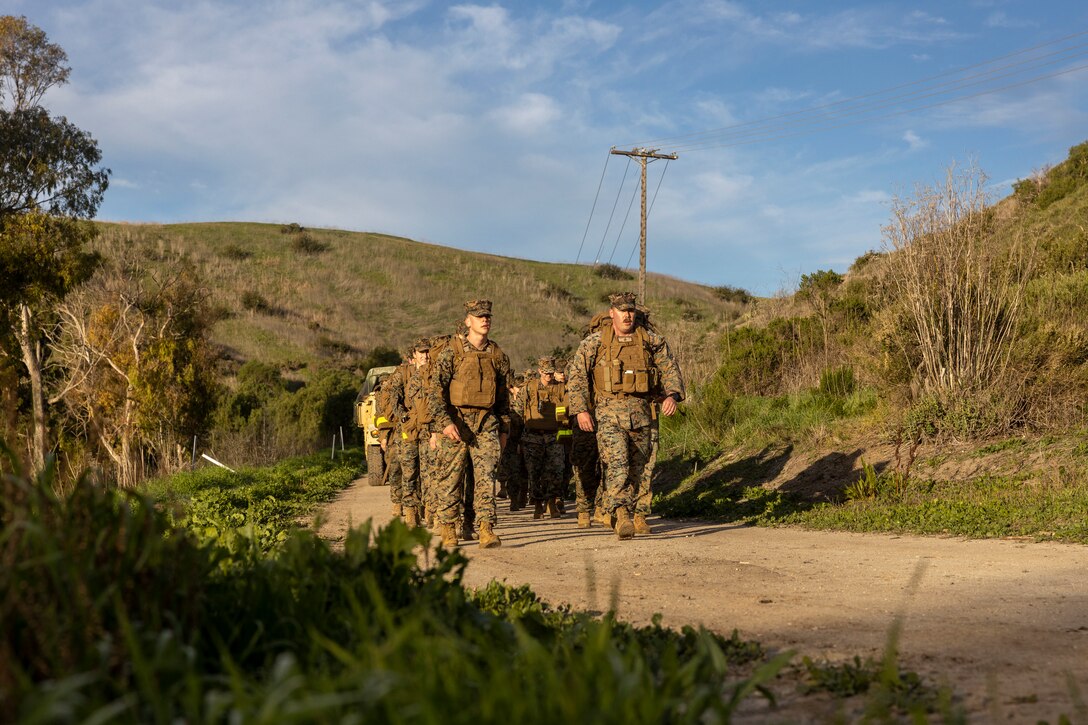 U.S. Marine Corps 1st Lt. Daniel McAlary (left) a Marine air/ground task force intelligence officer and Staff Sgt. Robert Schartz a cyber warfare operator with 1st Radio Battalion, I Marine Expeditionary Force Information Group lead their platoon on a hike on Marine Corps Base Camp Pendleton, California, January 28, 2022. The Electronic Warfare Platoon conducted an 8-mile hike to maintain readiness within the unit. The 1st Radio Battalion establishes, operates, and maintains the necessary intelligence information architecture to enable and provide signals intelligence, electronic warfare, and computer network exploitation capabilities. (U.S. Marine Corps photo by Cpl. Austin Gillam)