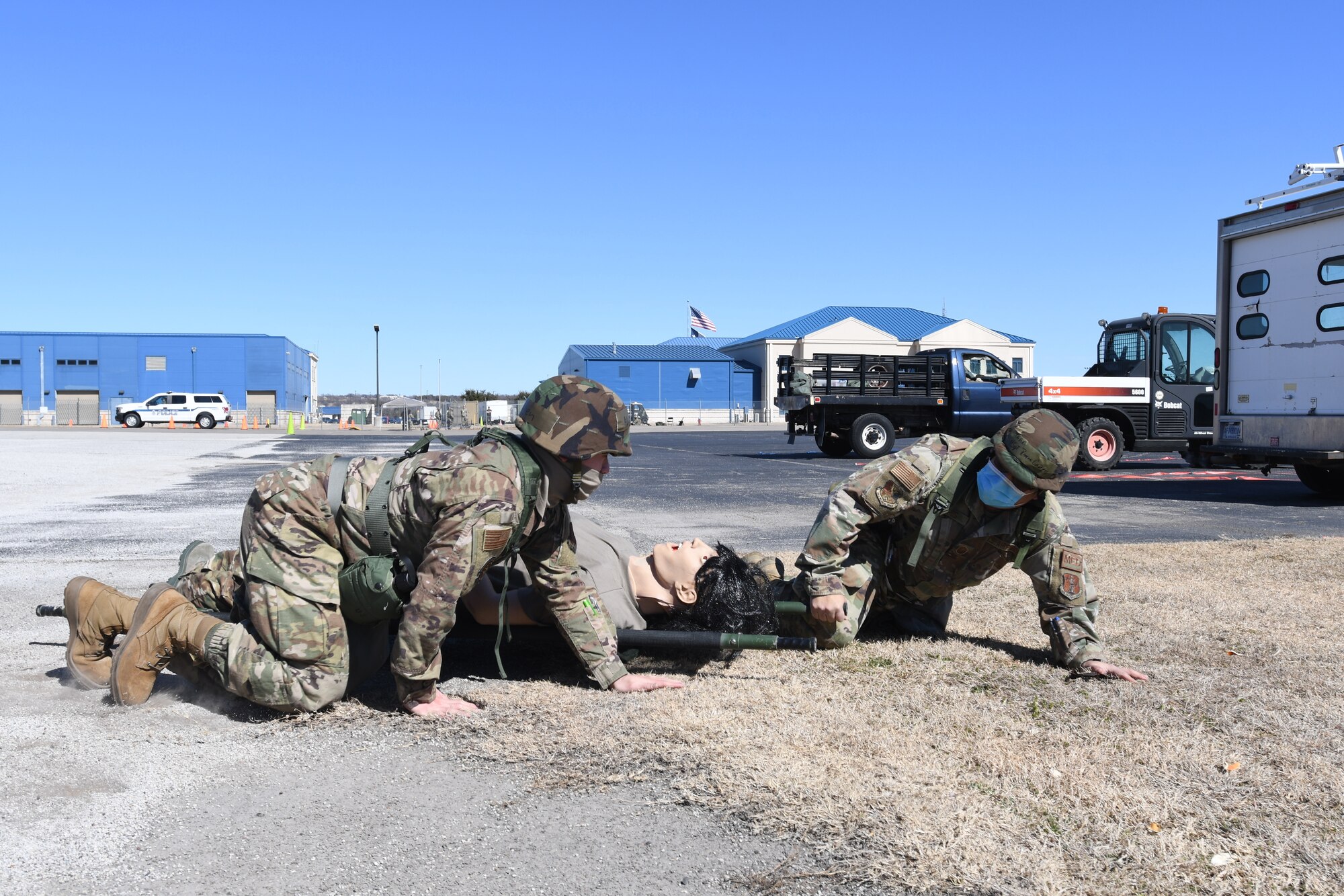 Airmen simulate self-aid buddy care on mannequin.