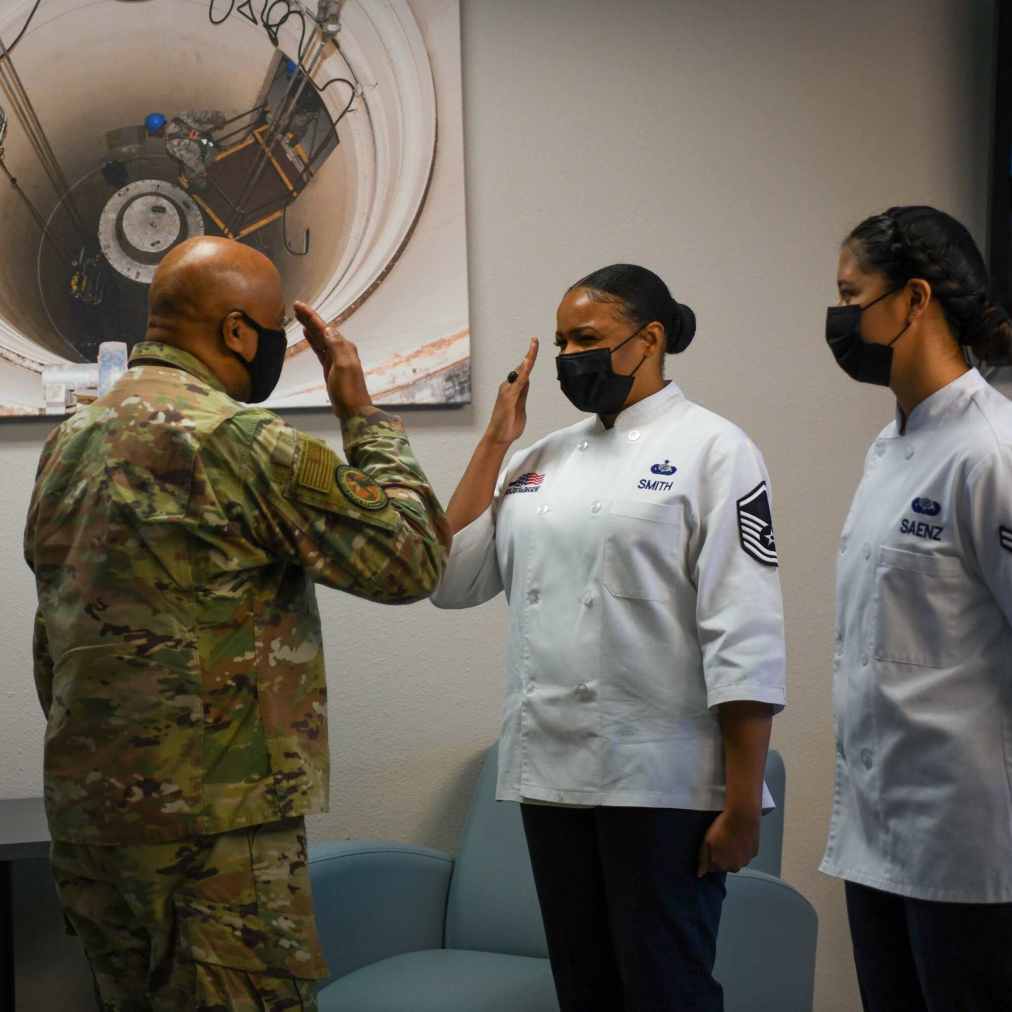 Master Sgt. Stasia Smith, Dining Facility manager, salutes Gen. Anthony Cotton, Air Force Global Strike Command commander, at Minot Air Force Base, North Dakota, Feb 24, 2022. While visiting Minot Air Force Base, Gen. Cotton conversed with airmen and leaders about their experiences protecting, interacting and maintaining assets in order to make informed integrated decisions for modernization programs. (U.S. Air Force photo by Airman 1st Class Evan Lichtenhan)