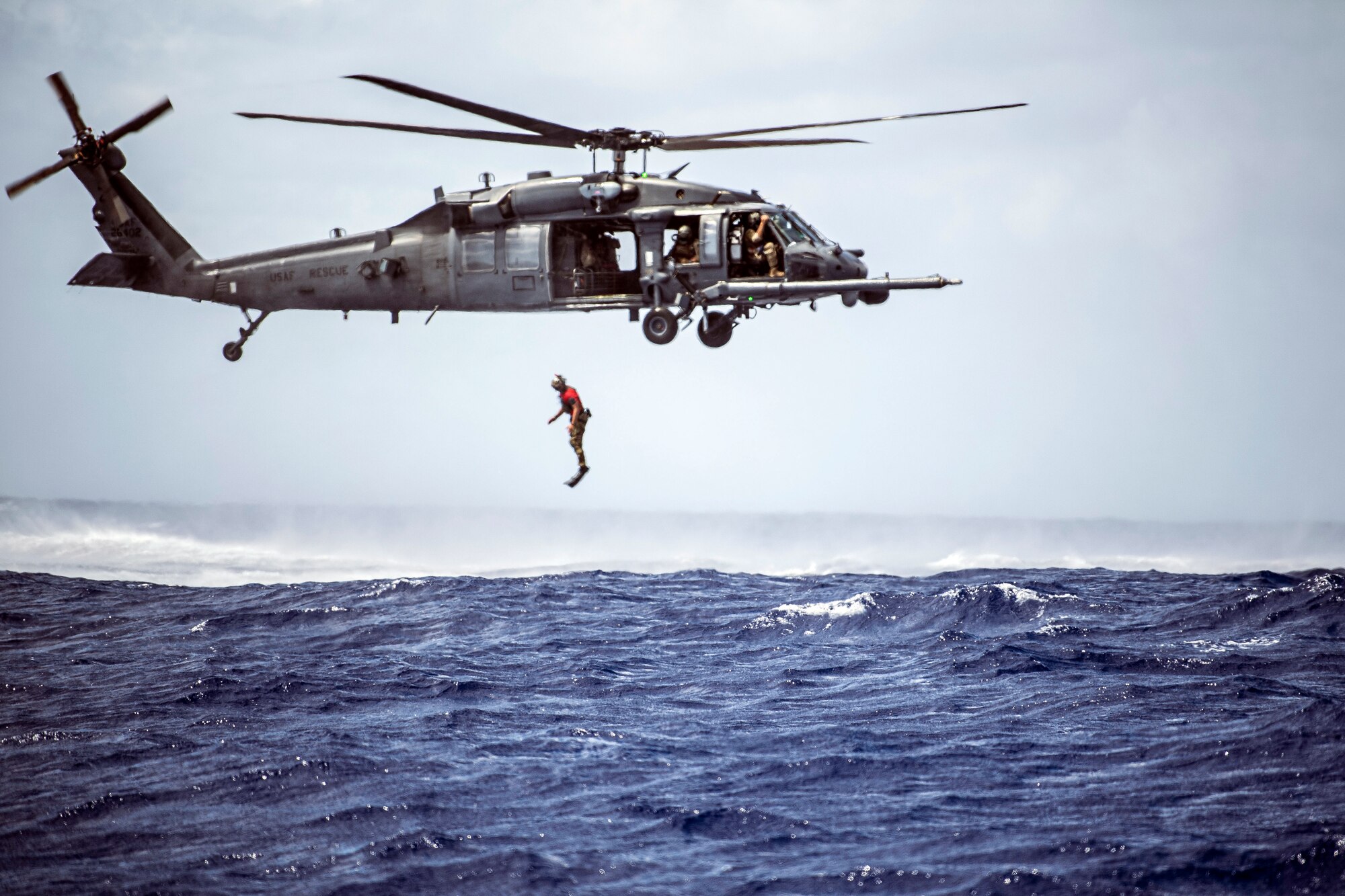 A U.S. Air Force pararescueman with the 31st Rescue Squadron jumps out of an HH-60G Pave Hawk