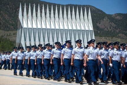 Many uniformed individuals march in a formation.