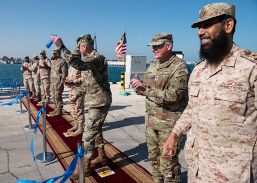 Lt. Gen. Scott A. Spellmon, the 55th Chief of Engineers and commanding general of U.S. Army Corps of Engineers, along with senior U.S. and Kuwaiti officials, holds up a souvenir from the ribbon-cutting ceremony opening the Kuwaiti Navy pier, Feb. 2, 2022. The renovated Navy pier and harbor house construction projects were managed by Transatlantic Division's Middle East District. Spellmon is in Kuwait reviewing Army Corps of Engineer projects and meeting with key leaders and stakeholders. (U.S. Army photo by Richard Bumgardner)