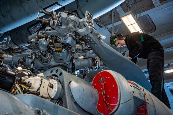 Aviation Machinist's Mate Airman James Nickley inspects corrosion on the main rotor head of the MH-60S Sea Hawk helicopter in the hangar bay of USS Harry S. Truman (CVN 75)