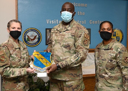 Joint Base Anacostia-Bolling Commander, U.S. Air Force Col. Cat Logan, and Command Chief, Chief Master Sgt. Christy Peterson, present Tech. Sgt. Damien Sawyer, Joint Visitor Center NCO in charge, with his Volunteer of the Year award on Feb. 14, 2022, at JBAB, Washington, D.C. Sawyer has been acknowledged for his service outside the fence line and across the country. (U.S. Air Force photo by Staff Sgt. Kayla White)
