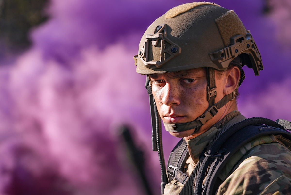 A security forces member and student in the Deployed Aircraft Ground Response Element qualification course stand in front of a plume of purple smoke on the Eglin range in northwest Florida, Dec. 14, 2021. DAGRE team members have specialized skills needed to provide a wide range of security in austere environments. (U.S. Air Force photo by Senior Airman Dylan Gentile)