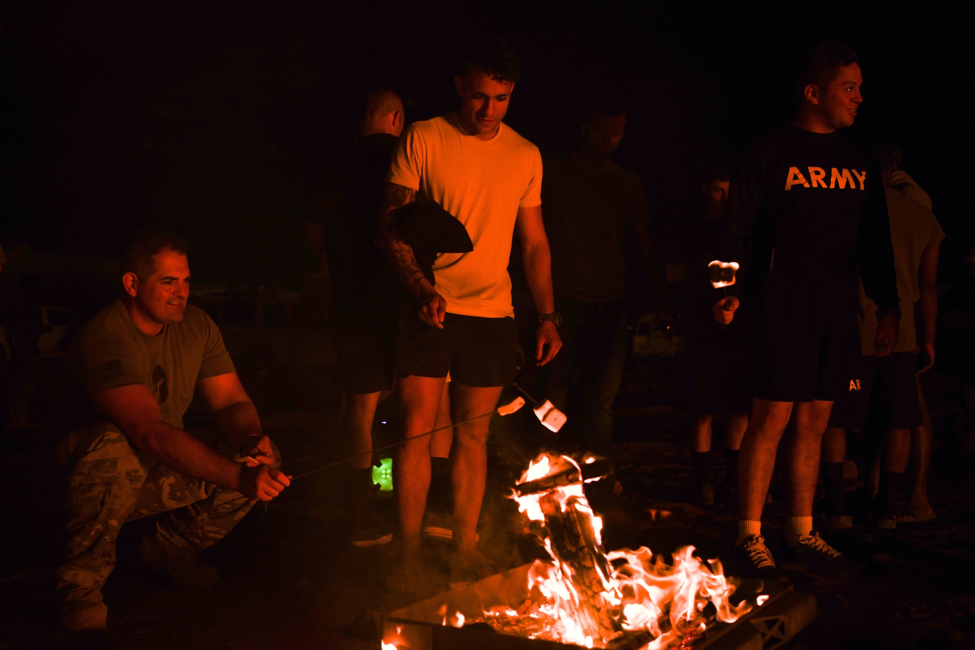 Joint service members roast marshmallows at Chabelley Airfield, Djibouti, Feb. 5, 2022. Morale events like this build relationships and encourage support and care for one another. (U.S. Air Force photo by Senior Airman Ericka A. Woolever)