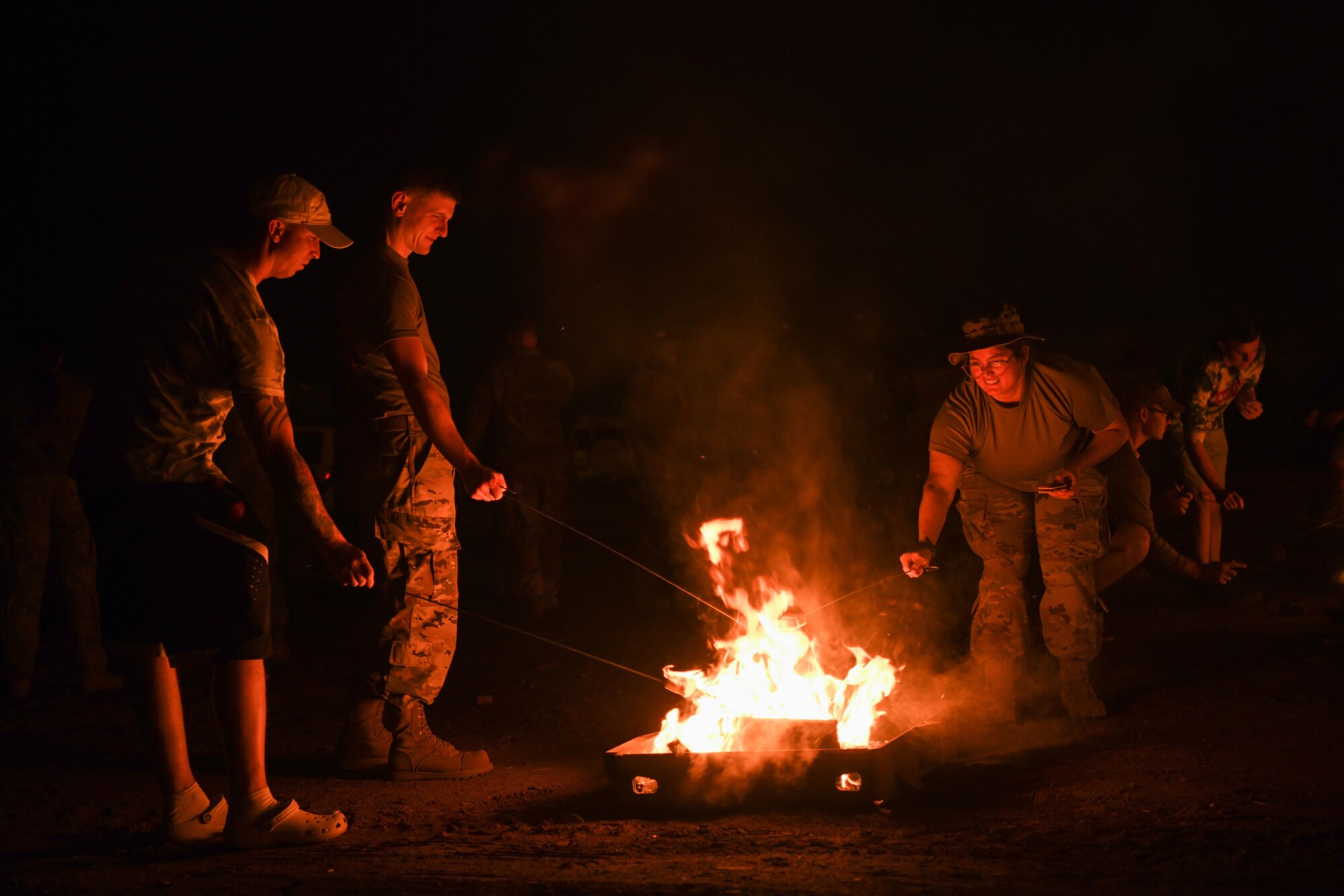 Joint service members roast marshmallows at Chabelley Airfield, Djibouti, Feb. 5, 2022. Morale events like this build relationships enabling Airmen and sister service members to care for and support each other. (U.S. Air Force photo by Senior Airman Ericka A. Woolever)