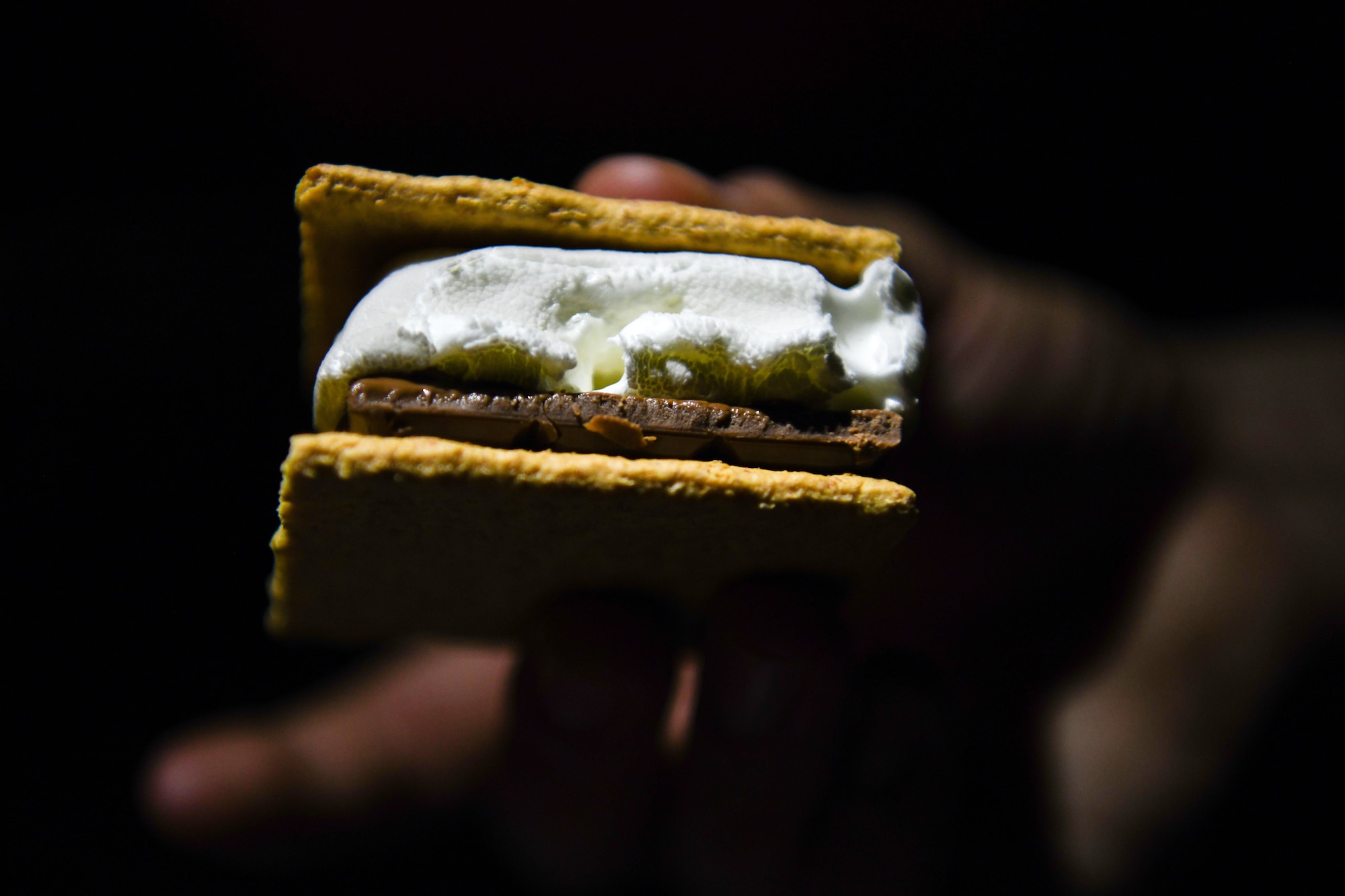 An Airman holds a s’more at Chabelley Airfield, Djibouti, Feb. 5, 2022. Morale events like this build relationships and encourage support and care for one another. (U.S. Air Force photo by Senior Airman Ericka A. Woolever)
