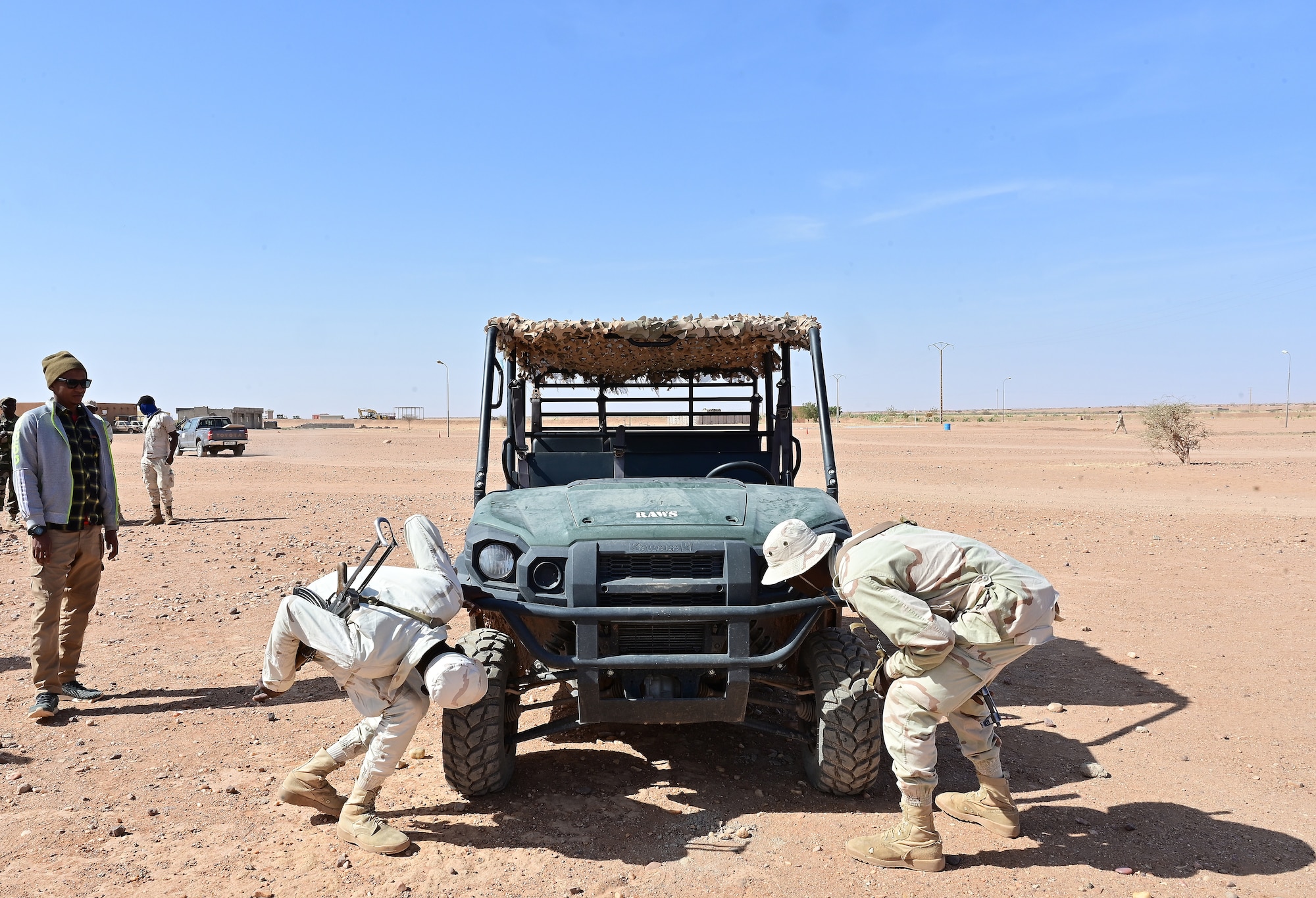 Two Niger Armed Forces (French language: Forces Armées Nigeriennes) members practice vehicle searches during a training event at Nigerien Air Base 201, Agadez, Niger, Feb. 17, 2022. The 409th ESFS hosted an eight-week course to train the FAN on various tactics such as combat lifesaving skills, weapon maneuvers, vehicle searches and patrol movements to better counter the escalating violent extremism in the tri-border region of Niger, Burkina Faso, and Mali. (U.S. Air Force photo by Tech. Sgt. Stephanie Longoria)