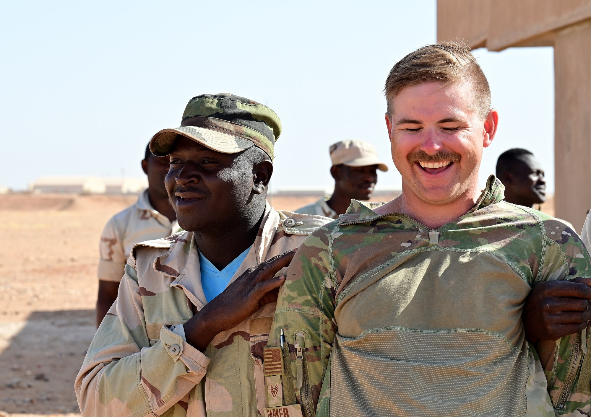 U.S. Air Force Staff Sgt. Tyler Parker, 409th Expeditionary Security Forces Squadron air advisor laughs at a joke from a Niger Armed Forces (French language: Forces Armées Nigeriennes) member during a training event at Nigerien Air Base 201, Agadez, Niger, Feb. 17, 2022. The training included detaining, handcuffing, individual and vehicle searches to help strengthen FAN defense capabilities in support of a more secure, stable Africa. (U.S. Air Force photo by Tech. Sgt. Stephanie Longoria)