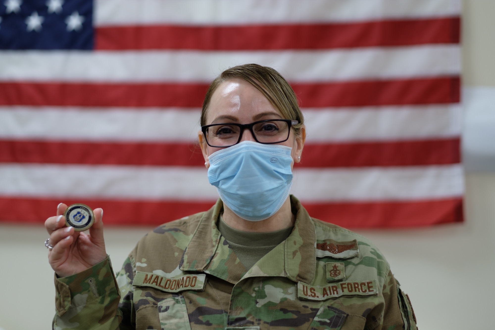 Tech. Sgt. Anita Maldonado, Aerospace Medical Service specialist with the 514th Aerospace Medicine Squadron, 514th Air Mobility Wing, poses for a photo after being coined by Lt. Gen. Richard W. Scobee, chief of the Air Force Reserve and commander of the Air Force Reserve Command on Joint Base McGuire-Dix-Lakehurst, New Jersey, Feb. 17, 2022. The Department of Defense, through U.S. Northern Command, and in support of the Department of Homeland Security, is providing transportation, temporary housing, medical screening, and general support for at least 11,000 Afghan evacuees at Liberty Village, in permanent or temporary structures, as quickly as possible. This initiative provides Afghan personnel essential support at secure locations outside Afghanistan (U.S. Air Force photo by 2nd Lt. Michael Hong.)