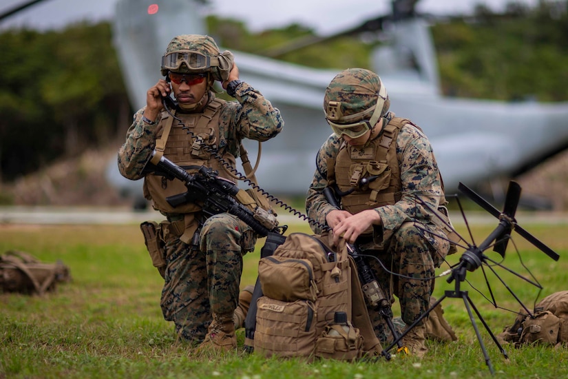 Marines talk on radios.