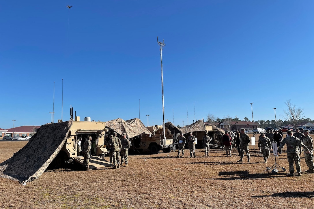 Soldiers set up a network with tents and vehicles.
