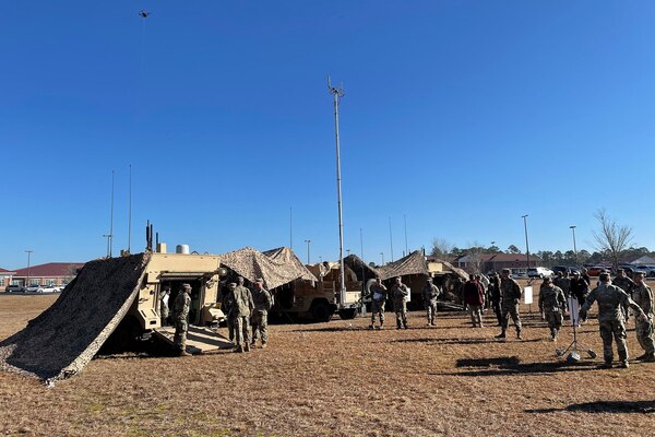 Soldiers set up a network with tents and vehicles.