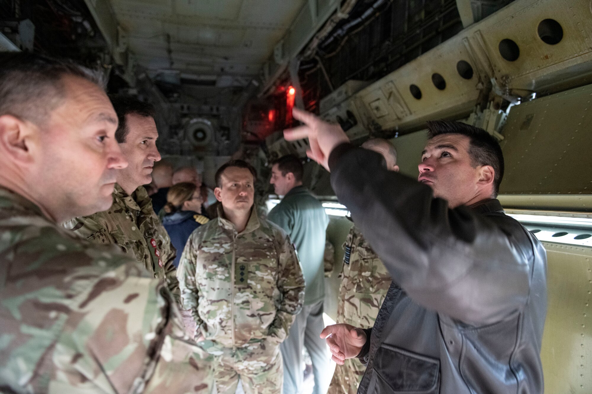 U.S. Air Force Lt. Col. Bryson Ayers, 69th Expiditionary Bomb Squadron commander, right, talks with members of The Defense Academy of the United Kingdom at RAF Fairford, England, Feb. 22, 2022. The members of the Defense Academy of the United Kingdom were at Fairford to learn about the capabilities of the B-52, as well as the ongoing operations, including the Bomber Task Force, at Fairford. (U.S. Air Force photo by Senior Airman Jason W. Cochran)