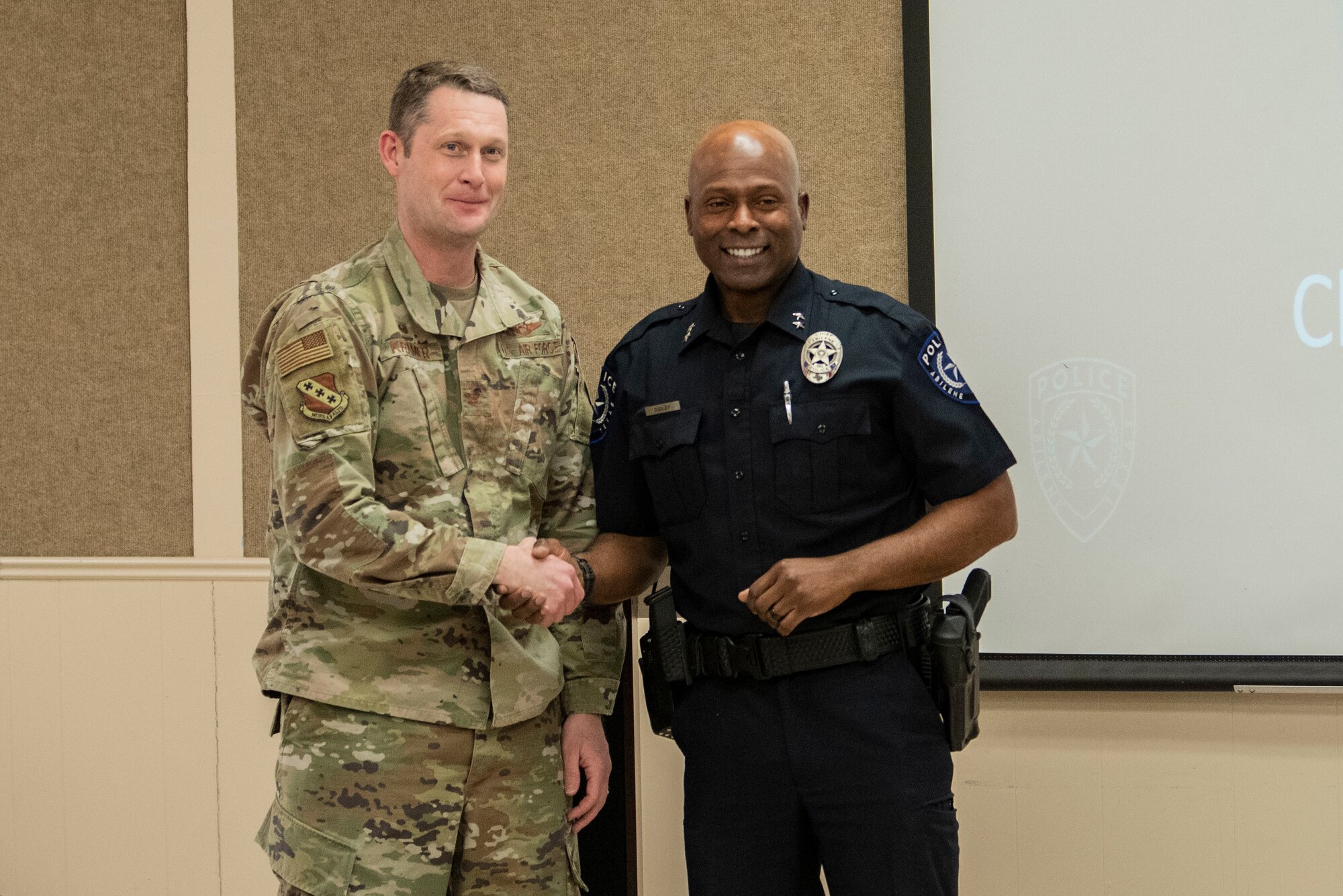 Col. Joseph Kramer, 7th Bomb Wing commander, left, shakes hands with Marcus Dudley, Abilene Chief of Police, during the Black History Month Luncheon at Dyess Air Force Base, Texas, Feb. 22, 2022. Following Dudley’s speech, Kramer thanked him for his time, partnership, and for sharing his inspiring story of adversity and hope.. (U.S. Air Force photo by Airman 1st Class Ryan Hayman)